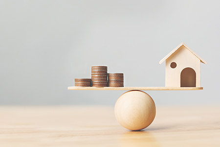représentation d'une balance entre immobilier et finances