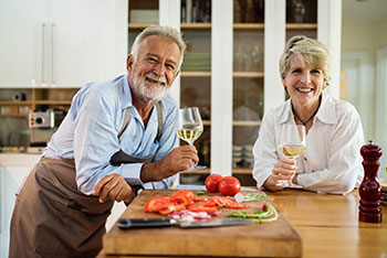 Deux personnes retraitées souriant dans une cuisine