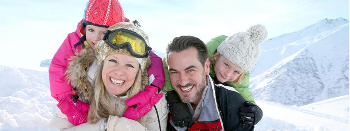 Une famille souriante s'amuse aux Gets dans la neige