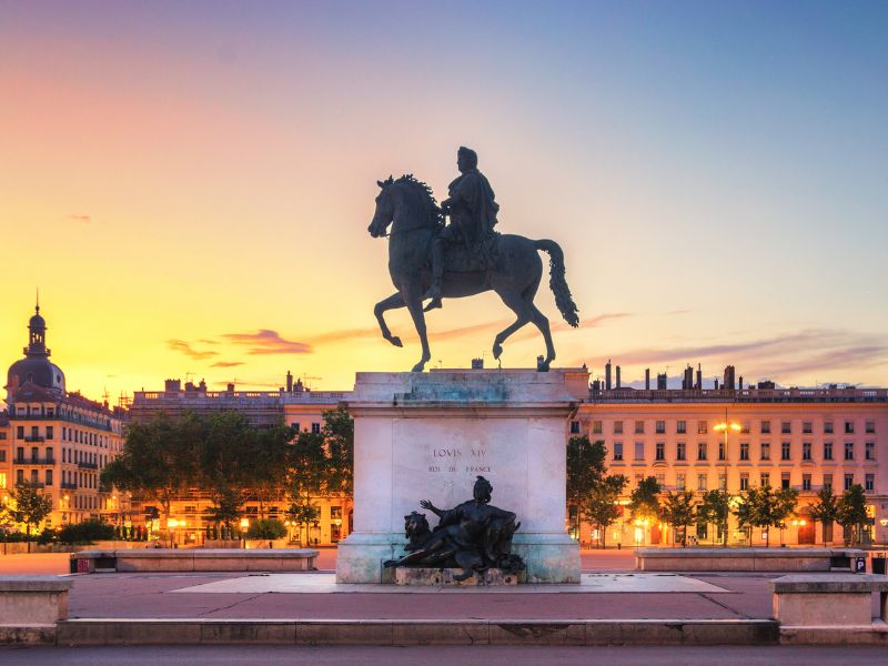 Statue équestre de Louis XIV à Lyon au crépuscule.