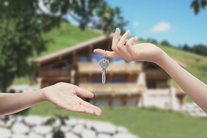 photo of a key exchange in front of a chalet