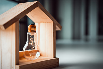 représentation d'une maison en bois avec ampoule